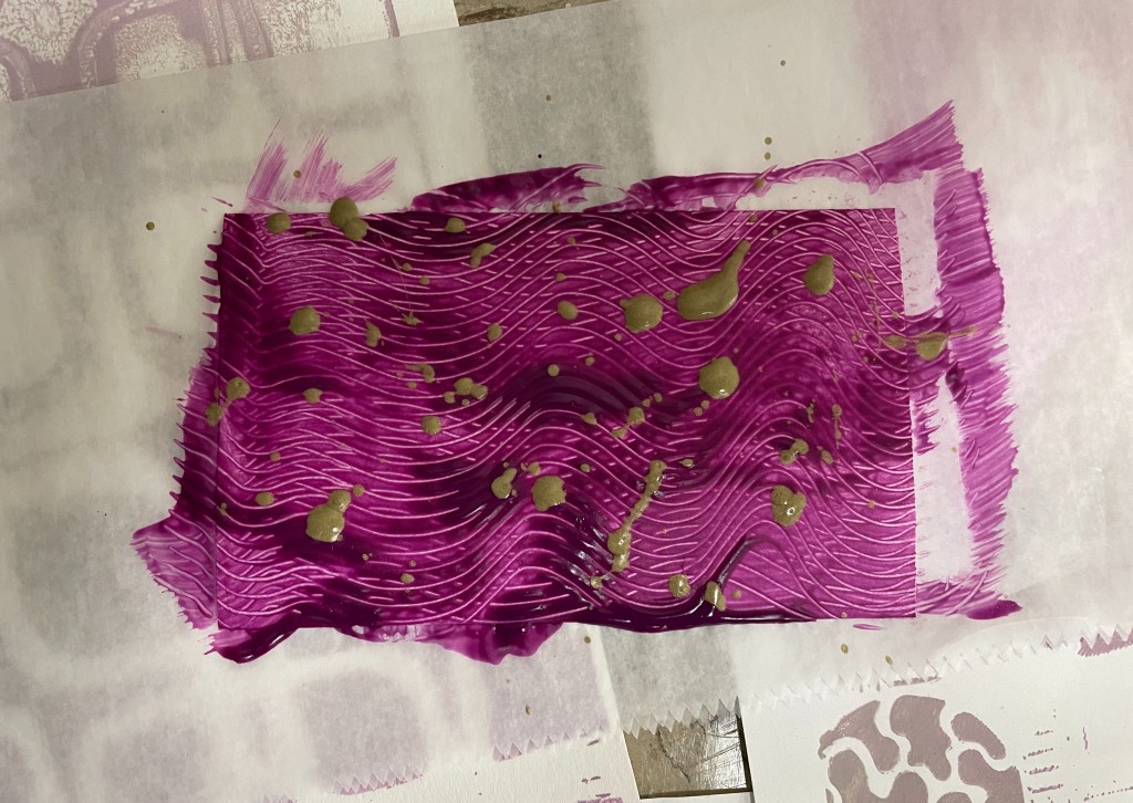 A purple background features a swirled texture. On top of it are golden drops of paint.